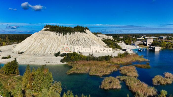 The crystal blue lake and mountain of the Rummu quarry in Estonia