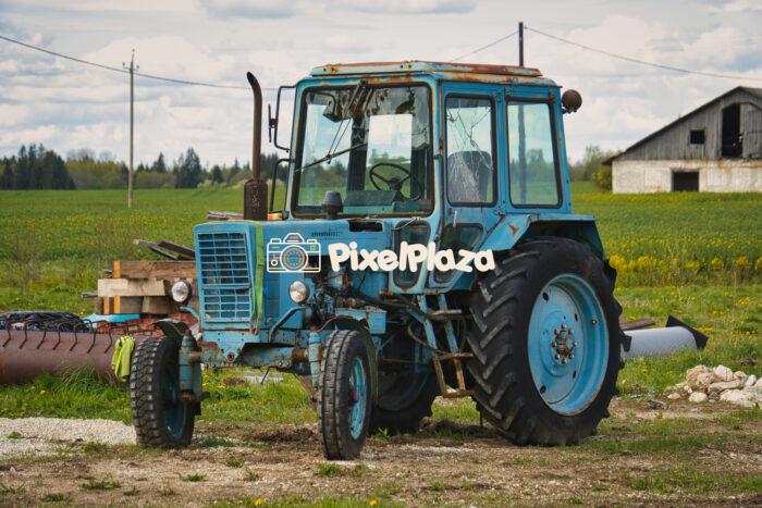Old Blue Tractor on a Rural Farm - Vintage Agricultural Machinery Old Blue Tractor on a Rural Farm - Vintage Agricultural Machinery