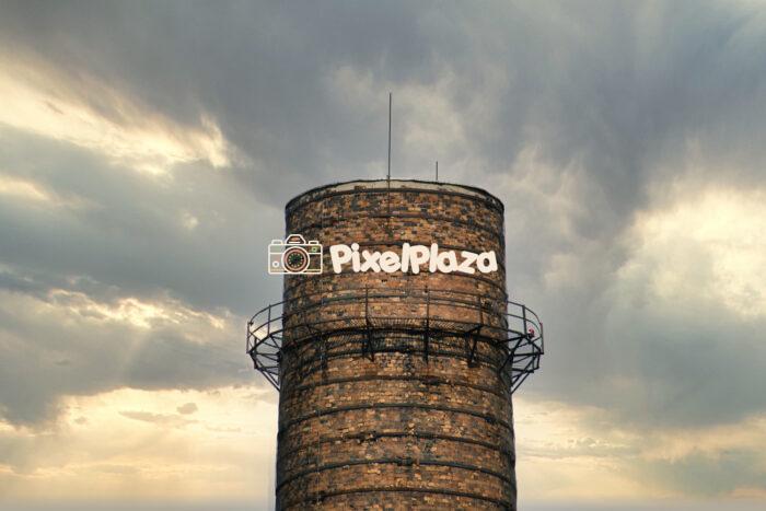 Old Industrial Brick Chimney Against Dramatic Sky Old Industrial Brick Chimney Against Dramatic Sky