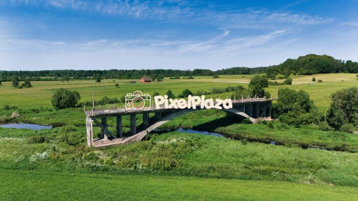 Abandoned Concrete Bridge Over River in Sāti, Latvia - Aerial View of Rural Landscape