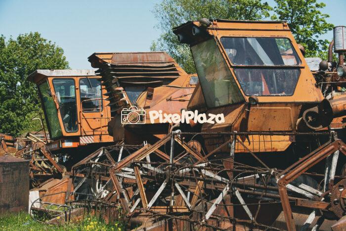 Abandoned Rusty Harvesters in Overgrown Field