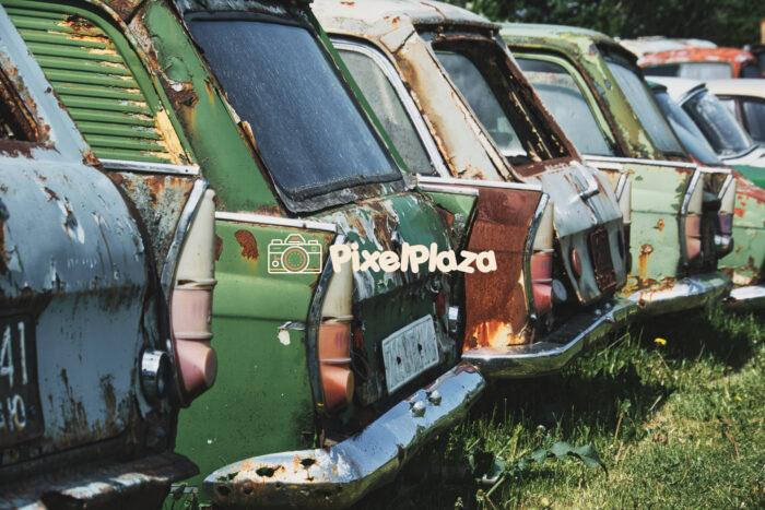 Row of Abandoned Soviet-Era Cars Rusting in Grass Field