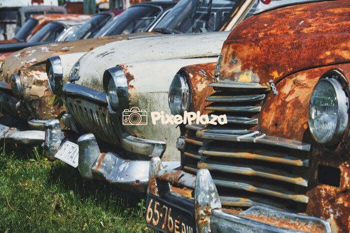 Row of Rusty Vintage Cars in Abandoned Lot