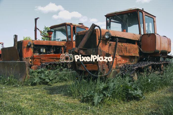 Rusty Abandoned Tracked Tractors in Overgrown Field Rusty Abandoned Tracked Tractors in Overgrown Field