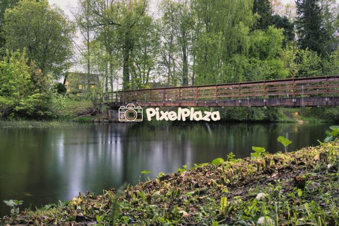 Tranquil Wooden Bridge Over Calm River in Spring