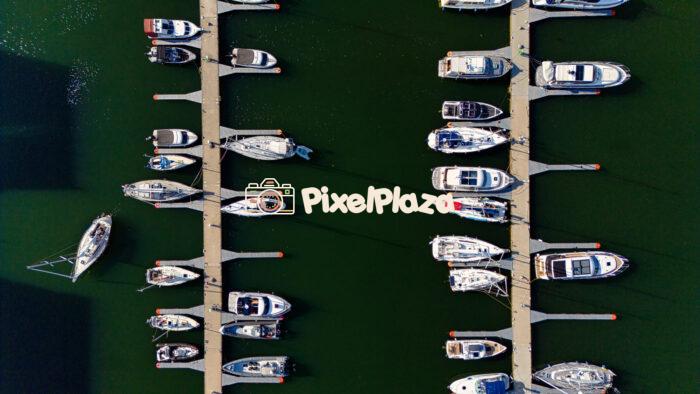 Aerial Top View of Yacht Marina - Boats Docked at Pier on Calm Water Aerial Top View of Yacht Marina - Boats Docked at Pier on Calm Water