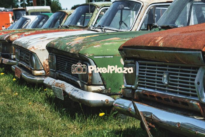 Row of Rusty Soviet-Era Vintage Cars Abandoned in Grass Field Row of Rusty Soviet-Era Vintage Cars Abandoned in Grass Field