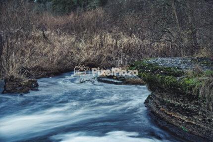 Scenic Long Exposure of Vahiküla Stream and Mossy Limestone Cliffs in Estonia