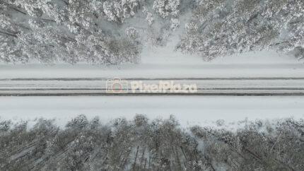 Vertical Takeoff Over Snowy Forest Road in Estonia - 4K Drone Video