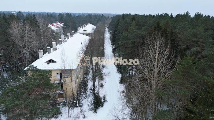 Winter Aerial View of Snowy Residential Buildings and Forest in Estonia - 4K Drone Video