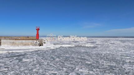 Frozen Baltic Sea and Red Beacon at Paljassaare, Tallinn - Winter Drone View