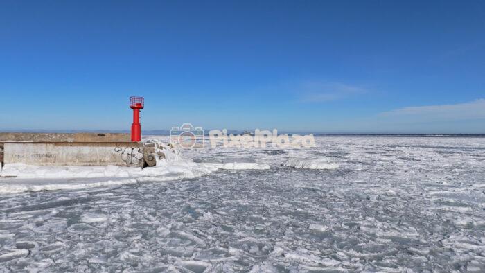 Frozen Baltic Sea and Red Beacon at Paljassaare, Tallinn - Winter Drone View