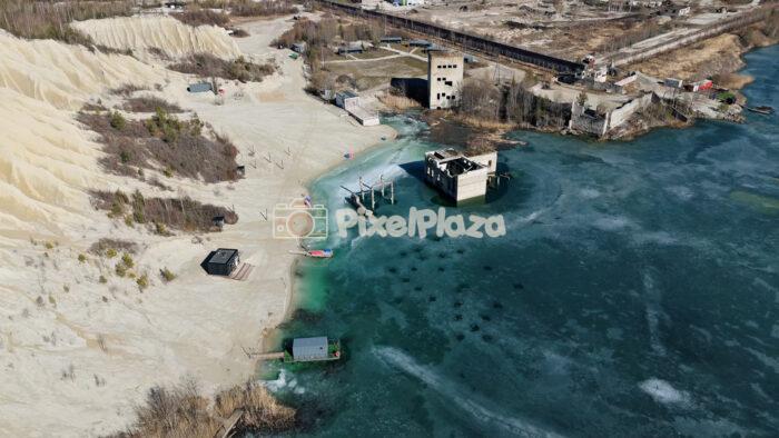 Frozen Rummu Quarry Lagoon and Submerged Ruins in Estonia Aerial View