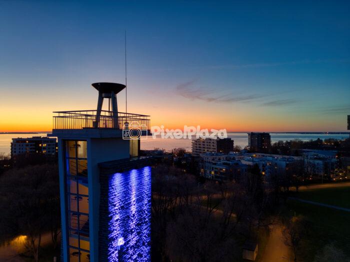 Drone View of Tallinn Song Festival Grounds Tower at Sunset with Blue Illumination