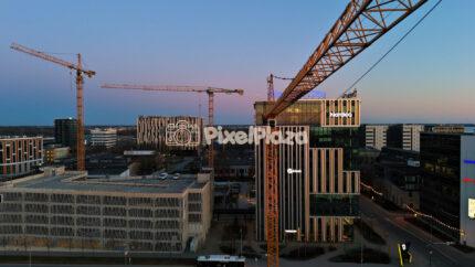 Tallinn business district skyline with cranes and modern offices at dusk