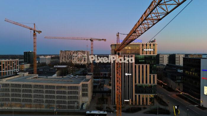 Tallinn business district skyline with cranes and modern offices at dusk