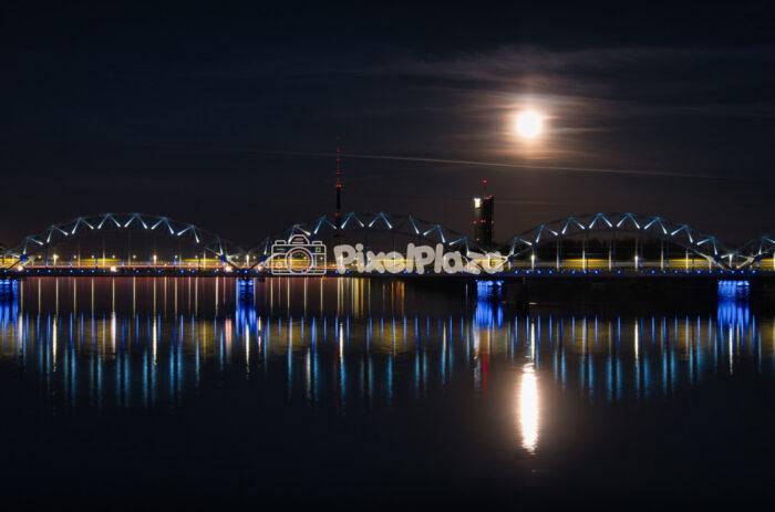 Night Railway Bridge and Moon over Daugava River in Riga Latvia
