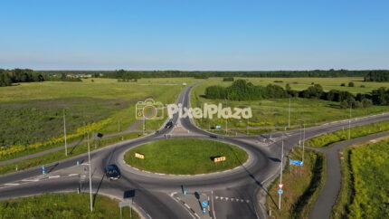 4K aerial drone video of cars driving through a rural roundabout