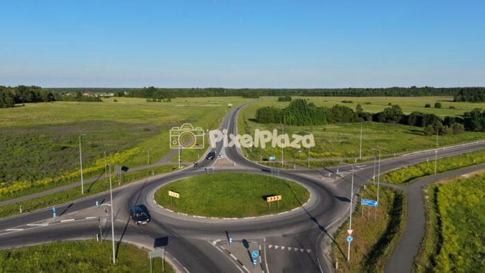4K aerial drone video of cars driving through a rural roundabout