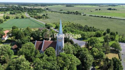 Aerial view of historic European church in lush green countryside summer landscape