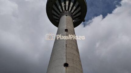 Low angle aerial view of iconic Tallinn TV Tower against dramatic sky in Estonia