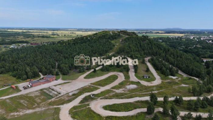 Aerial Slow Motion Tracking Shot of Winding Hillside Adventure Tracks