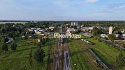 Aerial shot panning over rural train station and railway tracks