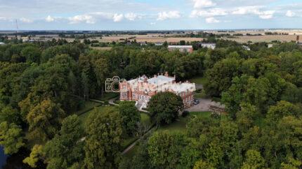 Aerial Flyover of Historic Red Brick Castle Hidden in Forest